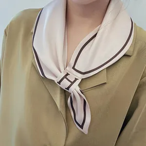 Detail of a retro French silk scarf with cream base and dark brown border accents