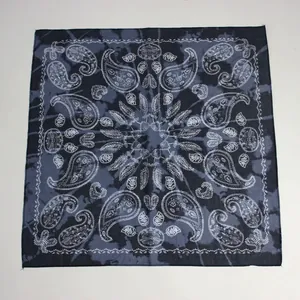 Vista dall'alto di una bandana blu scuro tie-dye con intricati motivi floreali paisley bianchi