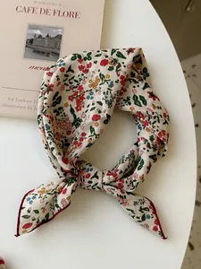 Close-up detail of cotton linen floral print square scarf with a vintage knotted style