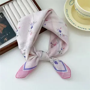 Vista dettagliata di un foulard con stampa floreale in rosa tenue e viola, elegante.