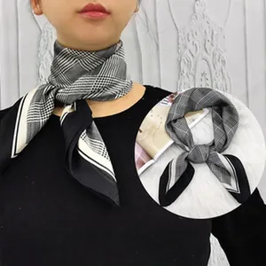 Close-up of a vintage black and white plaid skinny silk scarf worn by a model
