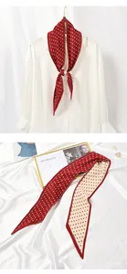 Detailed view of red pleated polka-dot scarf showing texture and styling on shirt