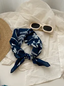 Detailed view of dark blue cotton linen scarf with elegant white floral patterns
