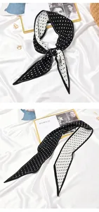 Detailed view of a pleated black and white polka dot thin scarf on white satin