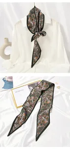 Detailed view of an elegant pleated floral skinny scarf styled on a white blouse collar
