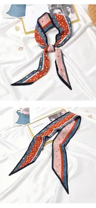 Detailed view of a pleated polka dot and striped skinny scarf in pink and navy blue