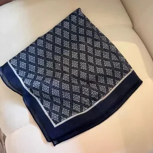 Vista dettagliata di un foulard quadrato blu navy con stampa floreale su sfondo bianco