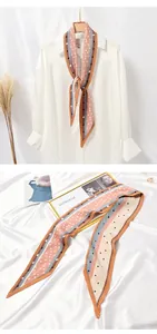 Detailed view of a pleated polka dot twilly scarf on elegant white satin background