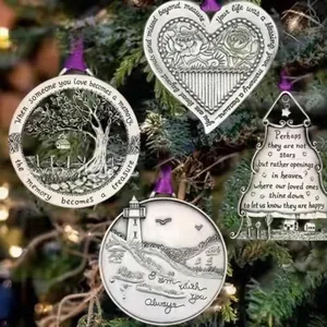 Close-up of memorial metal Christmas ornaments with engraved quotes hanging on a tree.