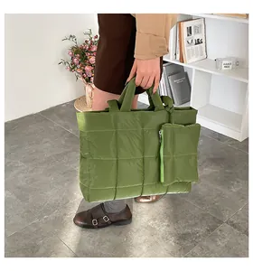 Detail shot of green quilted puffer tote bag with a small matching zippered pouch