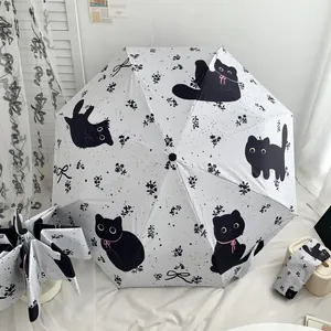 Close-up of white folding umbrella featuring cute black cat and floral patterns set