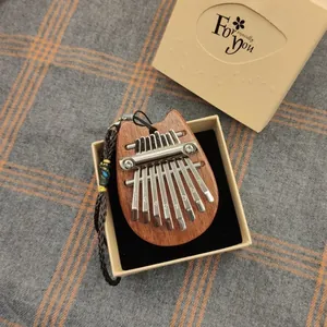 Close-up of 8-key mini cat-shaped solid wood Kalimba thumb piano in a gift box