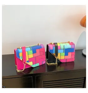 Gros plan de deux sacs carrés aux motifs Tetris vibrants avec des chaînes dorées élégantes