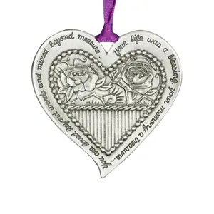 Detailed view of silver heart metal ornament with engraved floral design