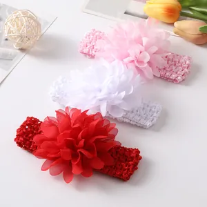 Gros plan de bandeaux doux et élastiques pour bébé avec grandes fleurs en mousseline