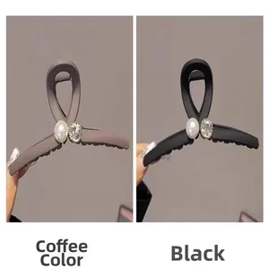 Vue détaillée des pinces à cheveux mates café et noir avec perle et strass décoratifs