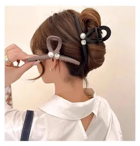 Détail d'une grande pince à cheveux mate avec perles et strass sur les cheveux d'un modèle