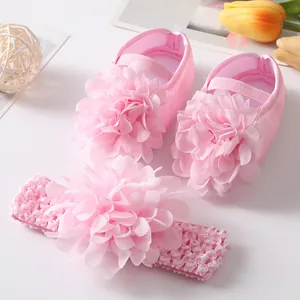Détail des chaussures de princesse rose pour bébé et du bandeau avec fleurs en tissu