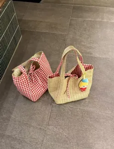 Détail de la texture en paille tisseé et de la doublure en toile à carreaux rouges des sacs