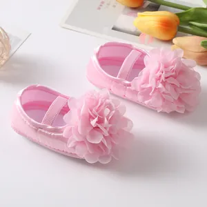 Vue détaillée de la fleur en mousseline rose sur la chaussure de princesse bébé