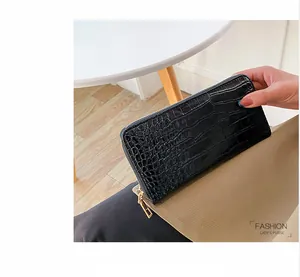 Vista detallada de una cartera larga para mujer de cuero PU con un patrón de cocodrilo negro.