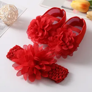 Vue détaillée de l'ensemble chaussures et bandeau rouge pour bébé avec fleurs