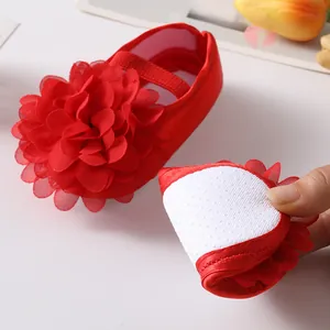 Détail montrant la semelle antidérapante souple et flexible du chausson bébé à fleurs rouge