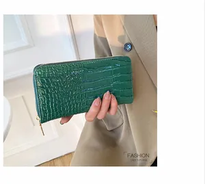 Vista detallada de una elegante cartera larga para mujer en cuero PU verde con cocodrilo.