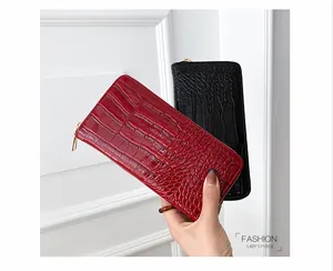 Primer plano de carteras largas de mujer en cuero PU con textura de cocodrilo roja y negra
