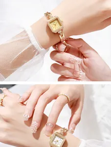Close-up detail of an elegant vintage gold square quartz watch with dainty metal bracelet.