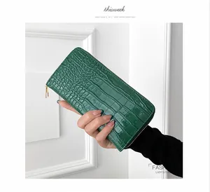 Detalle de cartera larga elegante para mujer en cuero PU verde con grabado de cocodrilo