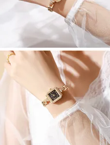 Detail view of an elegant vintage square gold watch with a jewelry bracelet on a woman's wrist