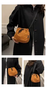 Detailed lifestyle view of a vibrant orange nylon drawstring bucket bag on a model