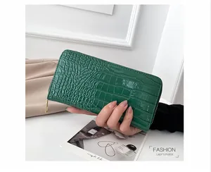 Primer plano de una cartera larga de cuero PU verde con motivo de cocodrilo