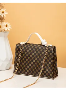Detail view of fashion printed small square handbag with gold chain and white handle