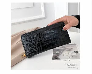 Detalle de cartera larga negra para mujer en cuero PU con textura de cocodrilo y cremallera