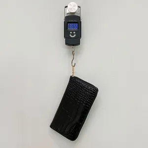 Cartera larga negra de piel sintética de cocodrilo pesada en una báscula digital