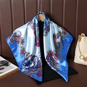 Elegant blue satin square scarf with colorful paisley pattern for sun protection.
