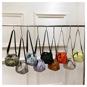 Lightweight nylon drawstring bucket bags displayed in multiple vibrant colors on a rack