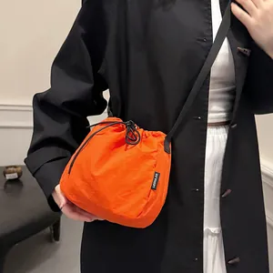 Lightweight orange nylon drawstring bucket bag with black strap for casual sports and daily use