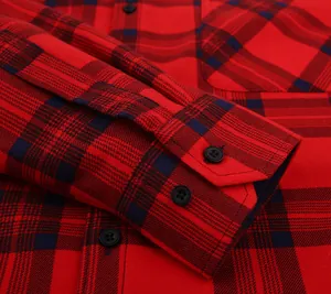 Close-up of red and navy plaid shirt cuff showing quality stitching and black buttons