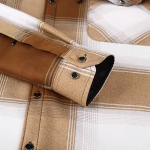 Close-up detail of a brown and tan plaid men's long-sleeve shirt showing cuff and buttons.
