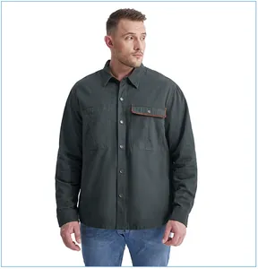 A detail shot of a men's dark grey cotton work shirt featuring a corduroy pocket accent