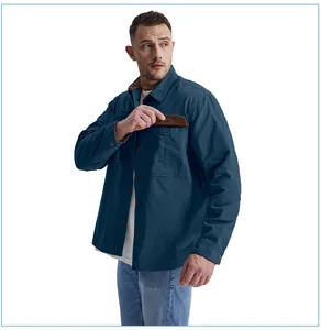 Detail view of men's blue cotton work shirt with brown corduroy pocket flap and buttons