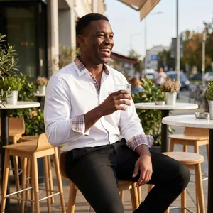 Chemise blanche pour homme avec col et poignets à carreaux contrastés dans un café