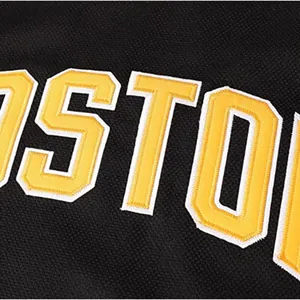 Detailed close-up of high-quality yellow embroidered BOSTON text on hockey jersey