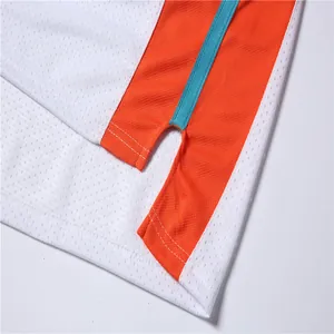 Vue macro détaillée de l'ourlet d'un maillot de basket en mesh blanc et orange avec fente