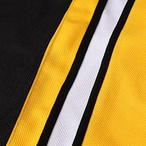 Detailed view of the breathable mesh fabric on a black and yellow hockey jersey
