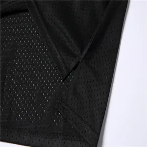 Dettaglio del tessuto a rete nero traspirante e dello spacco laterale di una maglia da basket.