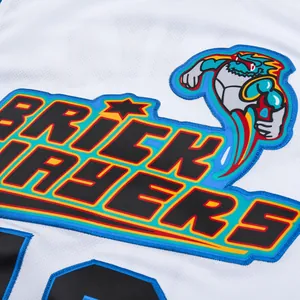 Macro view of white retro basketball jersey with 'Brick Layers' text and monster logo embroidery